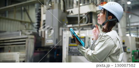 タブレットを持って工場機械を点検する女性作業員 タブレットを持って工場機械を点検する女性作業員 130007502