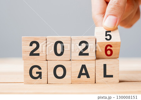 hand flipping block 2025 to 2026 GOAL text on table. Resolution, strategy, plan, motivation, reboot, business and New Year holiday concepts 130008151