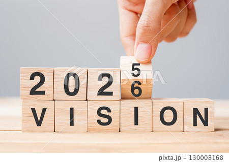 hand flipping block 2025 to 2026 VISION text on table. Resolution, strategy, goal, motivation, reboot, business and New Year holiday concepts 130008168