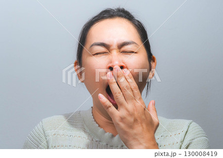 Asian woman yawning and covering mouth Asian woman yawning and covering mouth 130008419