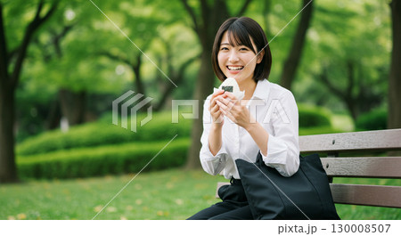 笑顔でおにぎりを手にする女性 130008507