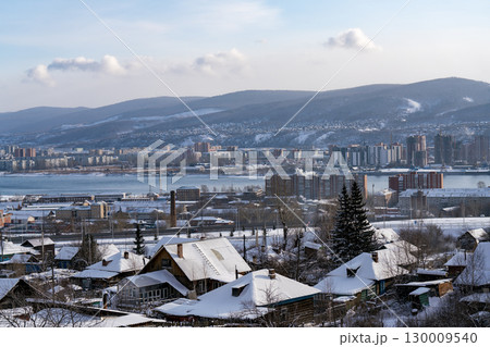 Industrial city on the river in winter against a cloudy sky. Industrial city on the river in winter against a cloudy sky. 130009540