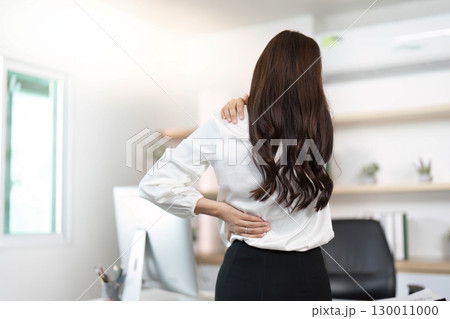 Posture Correction: Woman Holding Back Pain in Office Posture Correction: Woman Holding Back Pain in Office 130011000