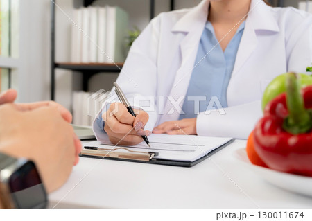 Close up asian nutritionist consulting patient in clinic, meal plan discussion, healthcare advice. 130011674