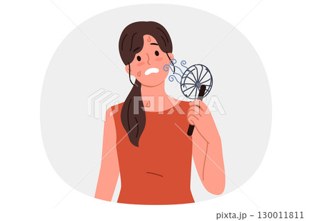 Woman uses electric fan to stop sweating and prevent exhaustion in hot summer weather Woman uses electric fan to stop sweating and prevent exhaustion in hot summer weather 130011811