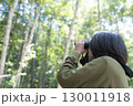 森の中で双眼鏡を構えて野鳥観察をする若者 130011918