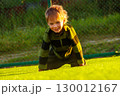The child goes in for sports at the stadium. The boy training before playing football. 130012167