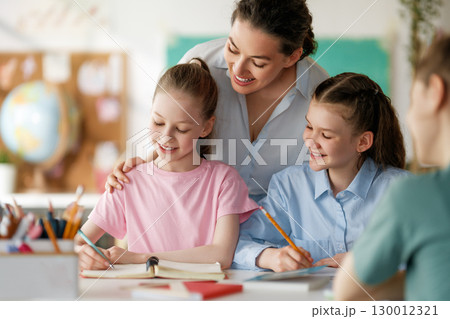 Happy kids and teacher at school Happy kids and teacher at school 130012321