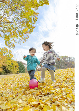 黄葉の公園で遊ぶ女の子と男の子 130012448