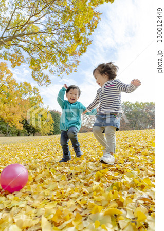 黄葉の公園で遊ぶ女の子と男の子 130012449