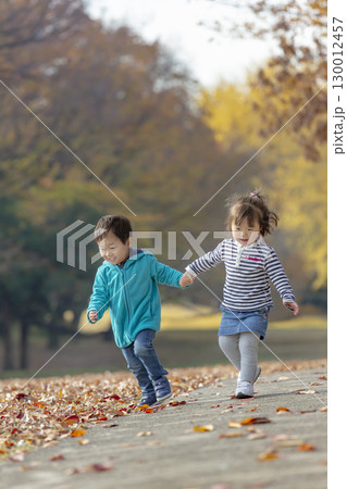 紅葉の公園で遊ぶ女の子と男の子 130012457
