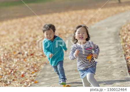 紅葉の公園で遊ぶ女の子と男の子 130012464