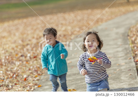 紅葉の公園で遊ぶ女の子と男の子 130012466