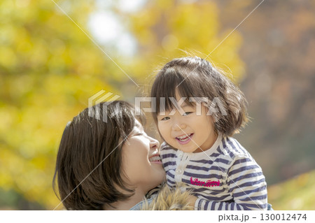 紅葉の公園で遊ぶ女の子と母親 130012474