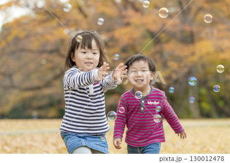 紅葉の公園で遊ぶ女の子と男の子 130012478