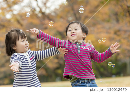 紅葉の公園で遊ぶ女の子と男の子 紅葉の公園で遊ぶ女の子と男の子 130012479