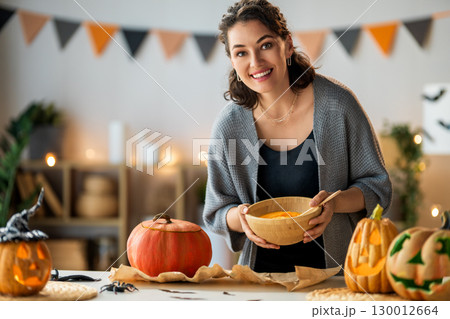 woman is carving pumpkin 130012664