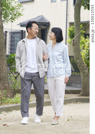 腕を組んで散歩する中年の夫婦 屋外 全身 腕を組んで散歩する中年の夫婦 屋外 全身 130013593