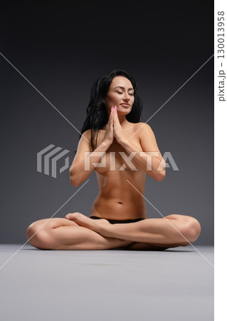 Beauty woman poses gracefully in studio setting during serene moment 130013958