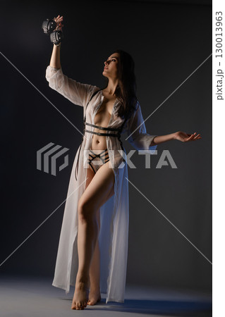 Graceful dance of beauty in sheer lingerie and weights under soft lighting 130013963