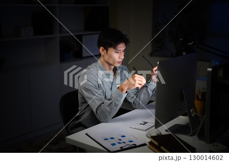 Overtime work concept with tired office worker staying up late in front of desktop Overtime work concept with tired office worker staying up late in front of desktop 130014602