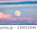 A lake with a cloudy sky and a full moon. The water is calm and the sky is overcast 130015046