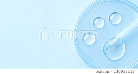 Drop of cosmetics and a pipette on a blue background. A product for skin, face or hair care. 130015115
