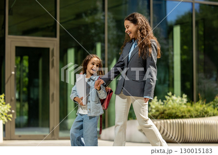 Stylish parent and child outdoors near modern building Stylish parent and child outdoors near modern building 130015183