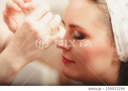 Make up artist using oil absorbing tissues sheets. 130015284