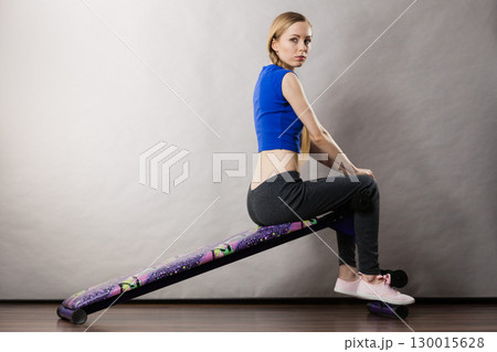 Woman training on bench for sit ups 130015628