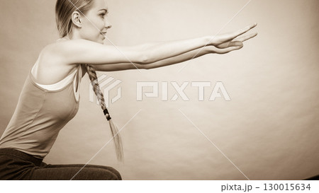 Woman training at home doing sit ups squats 130015634