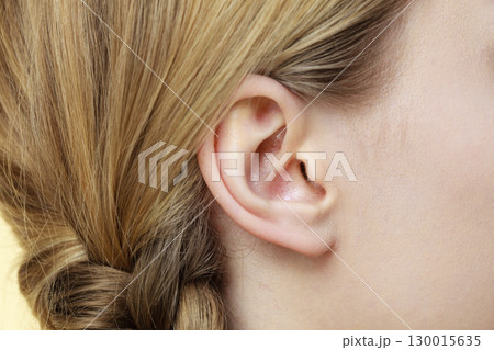 Close up on female ear and braid hair 130015635