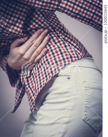 Woman feeling stomach cramps holding her belly Woman feeling stomach cramps holding her belly 130015643