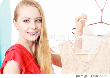 Happy smiling woman next to short white dress Happy smiling woman next to short white dress 130015646