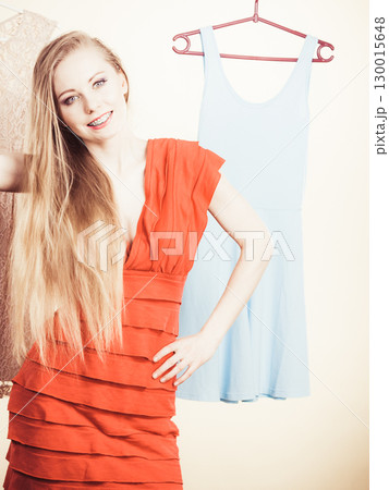 Woman in shop or wardrobe picking dress Woman in shop or wardrobe picking dress 130015648