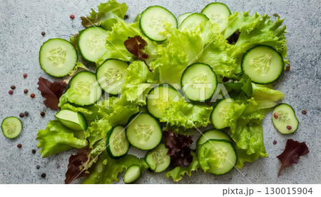 Fresh green salad with cucumber, arugula, red onion and spices on grey background Fresh green salad with cucumber, arugula, red onion and spices on grey background 130015904