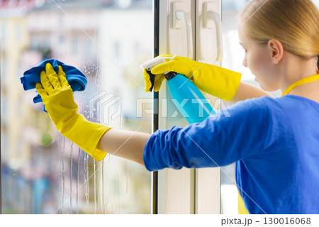 Woman cleaning window at home 130016068