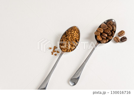 Roasted Coffee beans and instant coffee in spoons. Top view, white background 130016716