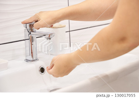 Hygiene routine person washing hands under modern faucet in clean bathroom 130017055