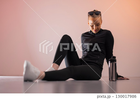 Woman in activewear resting with water 130017986