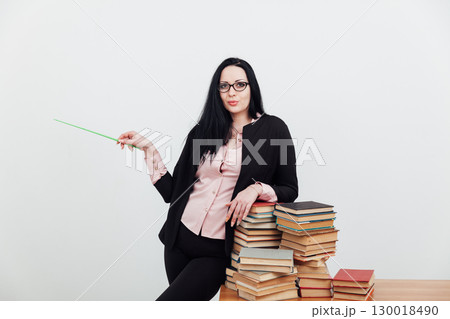 teacher with stacks of books on table 130018490