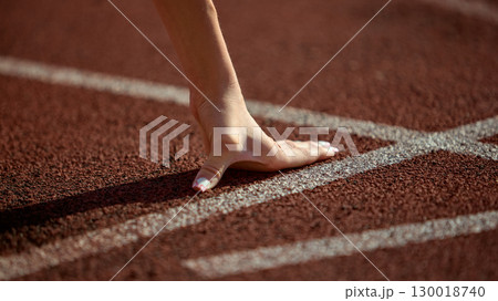 Close-up female athlete hand on starting line ready for sprint Close-up female athlete hand on starting line ready for sprint 130018740
