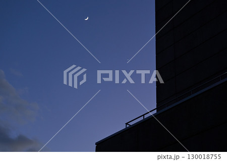 直線的な建物のシルエットと紫色の空に浮かぶ三日月と星 130018755