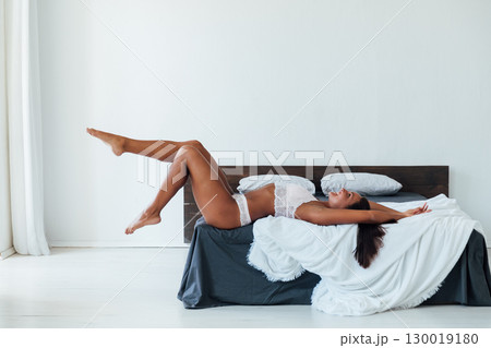 Brunette in lingerie listening to music in headphones and dancing in bedroom 130019180