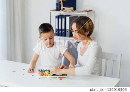 Female teacher engaged with boy educational games 130019306