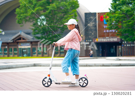 Asian girl is going to ride a scooter. Copy space 130020281