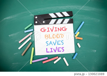 Giving Blood Saves Lives Message on Clapperboard with Chalk on Green Blackboard Background Giving Blood Saves Lives Message on Clapperboard with Chalk on Green Blackboard Background 130021089