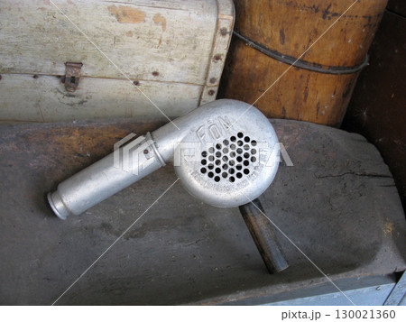 Vintage Metal Blow Dryer with Perforated End in Rustic Storage Area Vintage Metal Blow Dryer with Perforated End in Rustic Storage Area 130021360