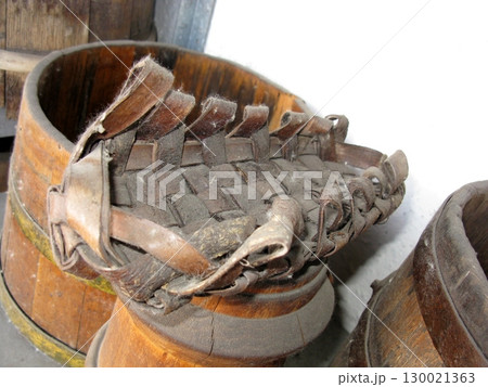 Rustic Wooden Barrel with Intricate Woven Leather Lid in Storage Area Rustic Wooden Barrel with Intricate Woven Leather Lid in Storage Area 130021363