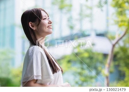 笑顔で空を見上げる女性 130021479